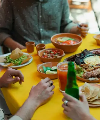 People sat around a dining table with food and drinks.