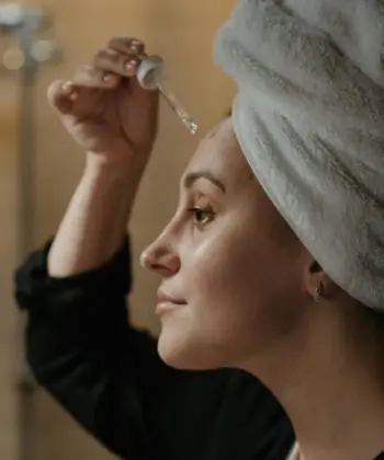 A woman applying a skincare product.