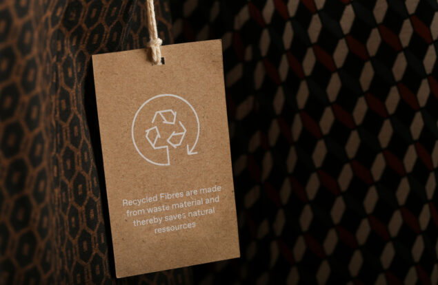 Close up of clothing tag with recycle icon. Recycling products concept. Zero waste, suistainale production, environment care and reuse concept.