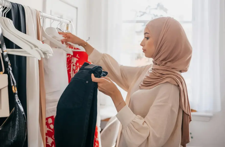 Woman wearing a headscarf looking at clothes on a shop rail